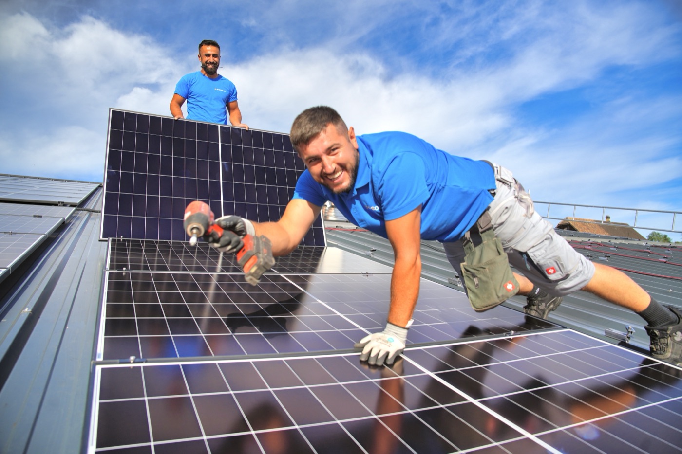 Zwei Ecosun-Monteure montieren Solarmodule auf einem Dach